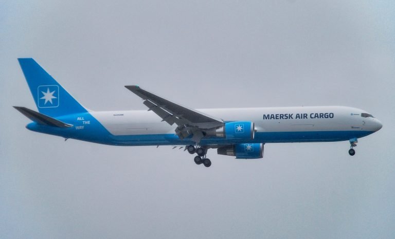 Maersk Air Cargo aircraft flying through a cloudy sky.