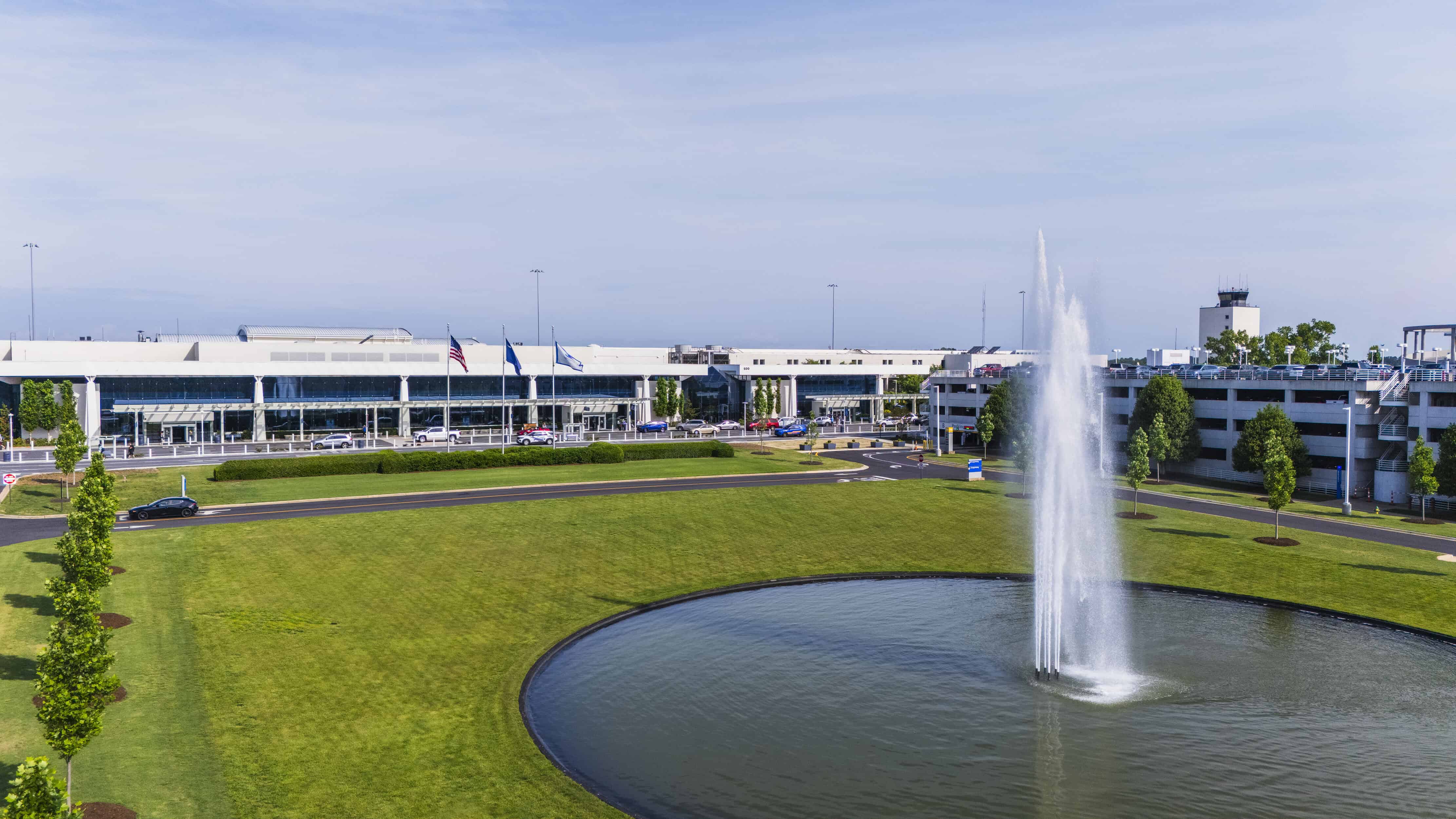 Front of the GSP Airport terminal building with green lawn and water fountain in fron.